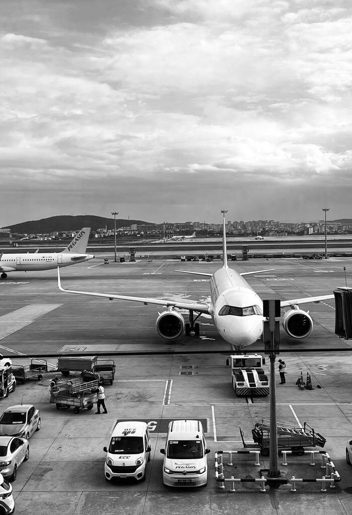 The Art of Drawing Readers In: Your attractive post title goes here Monochrome image of an airplane parked at the airport runway ready to board passengers.
