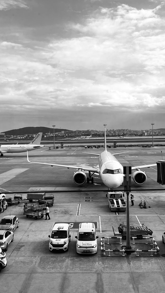 The Art of Drawing Readers In: Your attractive post title goes here Monochrome image of an airplane parked at the airport runway ready to board passengers.